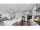 Open-concept kitchen with stainless steel appliances, a large island with seating, and views of the living area at 3421 Lebrun Path, Fuquay Varina, NC 27526
