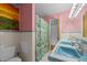 Well-lit bathroom featuring blue-tiled vanity, dual sinks, and colorful shower curtain at 3516 Swift Dr, Raleigh, NC 27606