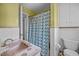 Colorful bathroom with a vintage pink sink, a patterned shower curtain, and classic ceramic tile at 3516 Swift Dr, Raleigh, NC 27606