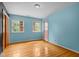 Bright bedroom with hardwood floors, two windows, closet space, and light blue walls at 3516 Swift Dr, Raleigh, NC 27606