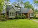 Attractive brick and shingle home featuring a lush green lawn, mature landscaping, and inviting curb appeal at 3516 Swift Dr, Raleigh, NC 27606
