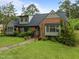 Charming brick home with mature landscaping and a well-maintained lawn on a sunny day at 3516 Swift Dr, Raleigh, NC 27606