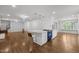 Modern kitchen island with white marble countertop and seating, complemented by hardwood floors and unique light fixtures at 3516 Swift Dr, Raleigh, NC 27606