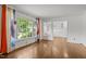 Bright living room with hardwood floors, large windows, and an open view into the updated kitchen area at 3516 Swift Dr, Raleigh, NC 27606