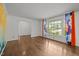Inviting living room with hardwood floors, bright windows, and colorful curtains at 3516 Swift Dr, Raleigh, NC 27606