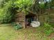Wooden storage shed for storing outdoor equipment with lush landscaping and mature trees at 3516 Swift Dr, Raleigh, NC 27606