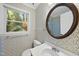 Bathroom featuring wallpapered walls, an oval mirror, and a window with natural light at 3517 Eden Croft Dr, Raleigh, NC 27612