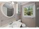 Bathroom with an oval mirror, wallpapered walls, and built-in storage at 3517 Eden Croft Dr, Raleigh, NC 27612