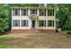 Charming two-story home with black shutters and a brick foundation, nestled among lush trees at 3517 Eden Croft Dr, Raleigh, NC 27612
