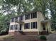Side view of a yellow two-story home featuring black shutters and inviting front entrance, surrounded by lush greenery at 3517 Eden Croft Dr, Raleigh, NC 27612