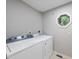 Well-lit laundry room with modern washer and dryer units and a unique octagon window at 3517 Eden Croft Dr, Raleigh, NC 27612