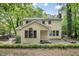The back of the house shows its siding and windows with the brick patio and wooded backyard beyond at 3517 Eden Croft Dr, Raleigh, NC 27612