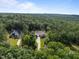 Overhead view of an estate showcasing its sprawling property, lush greenery and proximity to a forest at 387 Riverstone Dr, Pittsboro, NC 27312