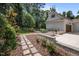 Landscaped backyard with stone walkways, garden beds, and lush greenery, creating a serene outdoor retreat at 387 Riverstone Dr, Pittsboro, NC 27312