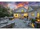 Inviting backyard patio featuring an outdoor kitchen, fireplace, comfortable seating, and stunning sunset views at 387 Riverstone Dr, Pittsboro, NC 27312