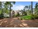 View of backyard featuring a stone fireplace and outdoor seating area, surrounded by lush landscaping and trees at 387 Riverstone Dr, Pittsboro, NC 27312