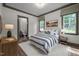 Charming bedroom with striped bedding, a decorative chandelier, and a view of the bathroom at 387 Riverstone Dr, Pittsboro, NC 27312