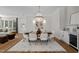 Bright dining room with chandelier, hardwood floors, and adjacent living room at 387 Riverstone Dr, Pittsboro, NC 27312