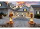 Stunning exterior of home showcasing three-car garage with custom doors and elegant landscaping with lanterns at 387 Riverstone Dr, Pittsboro, NC 27312