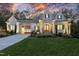 Inviting two-story home featuring a manicured lawn, double-door entryway, and attached carport at 387 Riverstone Dr, Pittsboro, NC 27312