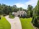 Beautifully landscaped home with a long driveway leading to the main house surrounded by trees at 387 Riverstone Dr, Pittsboro, NC 27312