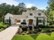 Charming two-story home with manicured landscaping, a light brick facade, and an attached carport at 387 Riverstone Dr, Pittsboro, NC 27312