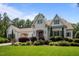 Charming two-story home with manicured landscaping, a light brick facade, and an attached carport at 387 Riverstone Dr, Pittsboro, NC 27312