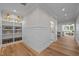 Hallway with white wainscoting, wood floors, and built-in shelving at 387 Riverstone Dr, Pittsboro, NC 27312