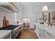 Bright kitchen with professional grade stove, stainless vent hood, farmhouse sink, and brass hardware at 387 Riverstone Dr, Pittsboro, NC 27312