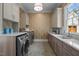 Well-equipped laundry room with modern washer, dryer, and ample counter space by the sink at 387 Riverstone Dr, Pittsboro, NC 27312