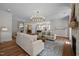 Large living room with hardwood floors, recessed lights, fireplace, and access to dining and kitchen at 387 Riverstone Dr, Pittsboro, NC 27312