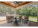 Inviting screened patio with comfortable seating, overlooking a lush backyard with a putting green at 387 Riverstone Dr, Pittsboro, NC 27312
