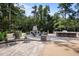 Luxurious outdoor patio features stone fireplace, outdoor kitchen with bar, and comfortable seating for relaxation at 387 Riverstone Dr, Pittsboro, NC 27312