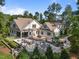 Spacious backyard featuring a full outdoor kitchen, patio, fireplace, and lush landscaping at 387 Riverstone Dr, Pittsboro, NC 27312
