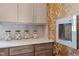 Close-up of wet bar with custom cabinets, stone countertop, and unique floral wallpaper at 387 Riverstone Dr, Pittsboro, NC 27312