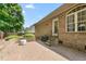 View of the brick patio with a built-in brick wall, steps to the yard, and a gas grill at this lovely property at 412 Whitt Ave, Burlington, NC 27215