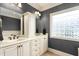 Bathroom with double sink vanity, tile floors, and glass block window for natural light at 412 Whitt Ave, Burlington, NC 27215