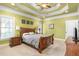 Inviting bedroom with ceiling fan, tray ceiling, carpeted floor, and wooden furniture at 412 Whitt Ave, Burlington, NC 27215