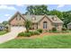 Charming single-Gathering home featuring a brick facade, two car garage, and manicured landscaping at 412 Whitt Ave, Burlington, NC 27215