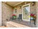 Cozy front porch seating with flowers, a patterned brick floor, and an oval glass front door at 412 Whitt Ave, Burlington, NC 27215