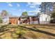 Wide view of the spacious backyard with a deck, a shed, and mature trees at 420 Nelson St, Durham, NC 27707