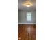 Bedroom with hardwood floors, neutral walls, baseboard trim and a window with blinds at 426 Smith St, Burlington, NC 27217