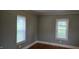Bedroom with hardwood floors, neutral walls, baseboard trim and two windows with blinds at 426 Smith St, Burlington, NC 27217