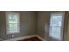 Bedroom with hardwood floors, neutral walls, baseboard trim and two windows with blinds at 426 Smith St, Burlington, NC 27217