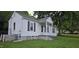 Single-story home featuring white siding, black shutters, covered front porch, and a well-kept lawn at 426 Smith St, Burlington, NC 27217