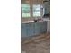 Bright kitchen featuring a double sink, blue cabinets, and vinyl floor at 426 Smith St, Burlington, NC 27217