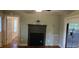 A living room with wood floors, decorative fireplace, and a glimpse into the adjacent kitchen and dining area at 426 Smith St, Burlington, NC 27217