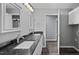 Modern bathroom featuring double vanity, dark countertops, framed mirrors, and wood-look flooring at 427 Elm Ct, Burlington, NC 27217