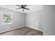 A gray bedroom featuring hardwood floors, a ceiling fan, and a window at 427 Elm Ct, Burlington, NC 27217