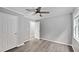 Bedroom featuring hardwood floors, two white doors and trim, a ceiling fan, and a window at 427 Elm Ct, Burlington, NC 27217